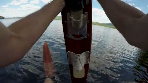 Punto de vista de un hombre que se pone esquís acuáticos de madera vintage en un muelle de un lago — Vídeo de stock
