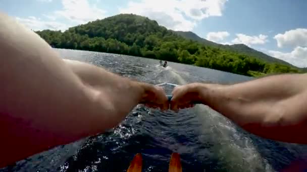 Punto de vista del joven esquí acuático en un lago de montaña azul claro con destello de lente — Vídeo de stock