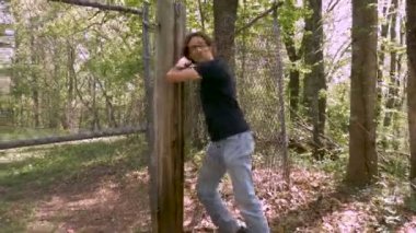 Adam takip ediliyor bir zincir bağlantı çit keser ve ormanın içinde çalışır