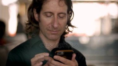 Adam onun 30'lu veya 40'lı kamera ve gülümsüyor akıllı telefon görünüyor kullanarak