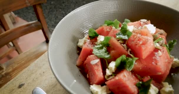 Закрыть здоровый арбузный салат с мятой и сыром фета в миске — стоковое видео