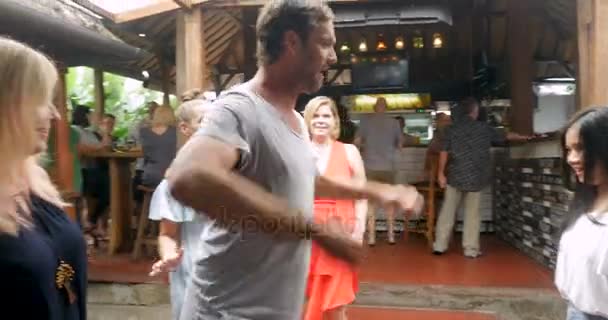Muž tančí se skupinou žen sundá košili v baru — Stock video