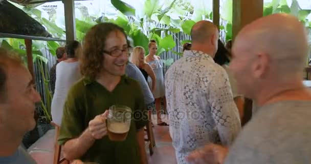 Группа друзей-мужчин, приветствующих и празднующих вместе в баре — стоковое видео