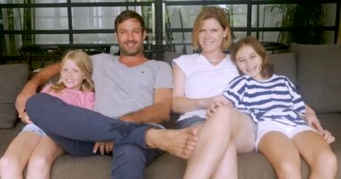 Bir mutlu gülümseyen aile kanepede birlikte oturma portre