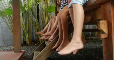 Grup genç kızların çıplak ayak dışında otururken bacaklarını sallanan ile