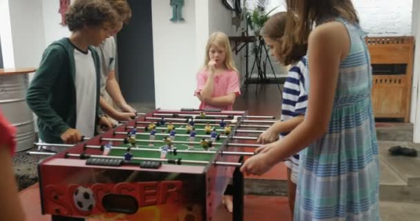 Niños pequeños jugando futbolín juntos chicos contra chicas — Vídeo de stock