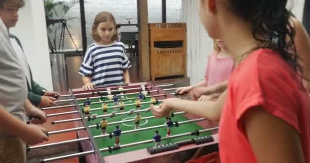 Een groep jonge vrienden spelen tafelvoetbal samen jongens tegen de meisjes — Stockvideo