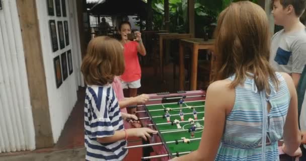 Joven chica multiétnica tomando fotos o video de sus amigos jugando futbolín — Vídeo de stock