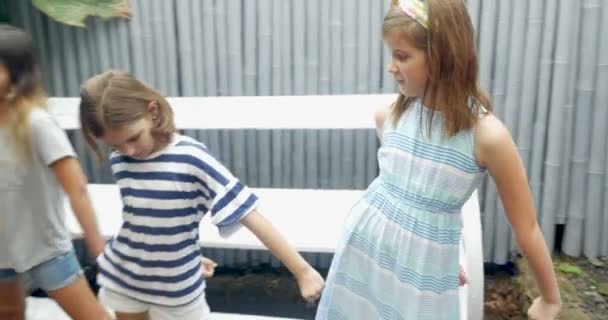 En ung flicka lär sina vänner att göra en dans rutin — Stockvideo