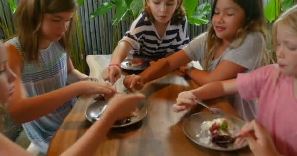 Group of diverse young children sharing desserts at a restaurant — Stock Video