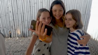Üç farklı çoklu etnik kız bir cep telefonu ile bir selfie alarak arkadaşlar