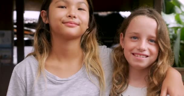 Two young girls smiling with their arms around each other's shoulders — Stock Video