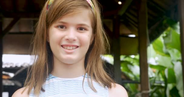 Porträt eines süßen 11-12 jährigen Mädchens mit einem Stirnband, das lächelt