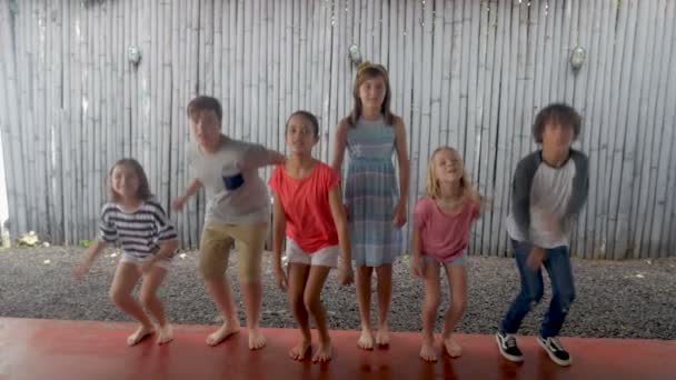 Meninos e meninas felizes idade 11 - 13 pulando juntos em câmera lenta — Vídeo de Stock
