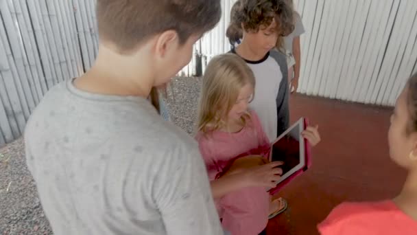 Groep van jonge pre tienerkinderen een tablet samen kijken — Stockvideo