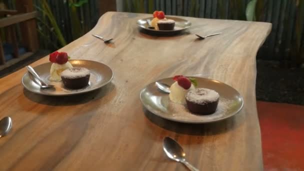 Drie platen van desserts met ijs, aardbeien en chocolade cake — Stockvideo