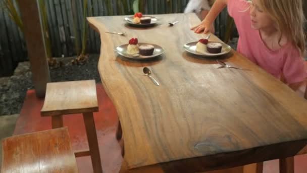 Grupo diverso de jovens famintas que chegam a uma mesa com sobremesas — Vídeo de Stock