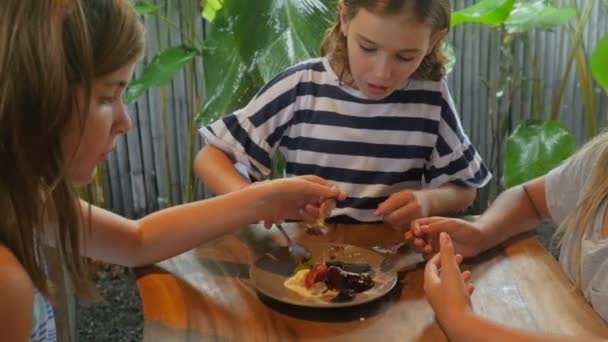 Three young multi racial friends sharing a plate of lava cake dessert — Stock Video