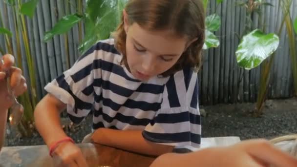 Close up of a young 11 - 12 year old girl getting a spoonful of dessert — Stock Video