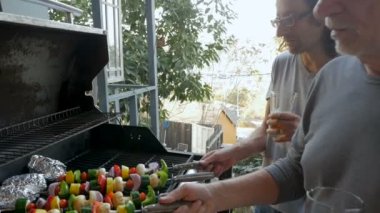 Büyük baba ve oğlu ızgara sebze kebap ve bir Barbekü dışında patates