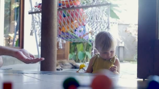 Schattig baby geeft een gele bloem tot een volwassen man in slow motion — Stockvideo