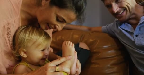 女と男が笑っていると自分の若い健康な幼児の赤ちゃんと遊ぶ — ストック動画