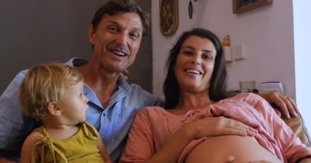 Pregnant mother, father, and infant child saying goodbye on a video chat — Stock Video