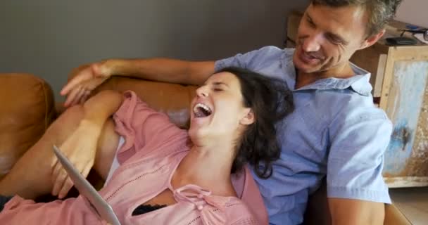 Pregnant happy laughing woman and man with a digital tablet — Stock Video