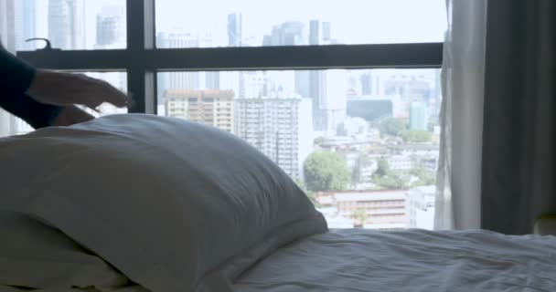 Almohadas de peluche persona en una cama con una vista urbana de la ciudad desde el dormitorio — Vídeos de Stock