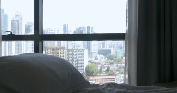 Kippen Sie aus dem Fenster auf die Stadt in ein leeres Bett mit einem Kissen — Stockvideo