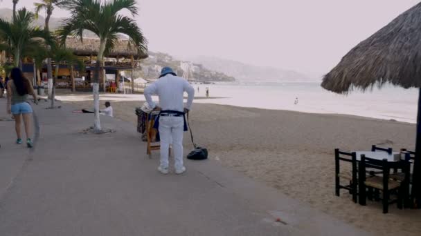 Вендор завязывает фартук, готовится к дню продажи на пляже. — стоковое видео