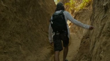 Adam parmağıyla kayalık duvar dokunmadan dar bir yol aracılığıyla hiking