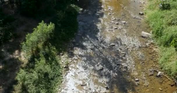Inclinez-vous vers le haut d'une rivière qui coule loin de la caméra pendant la journée à côté des maisons 