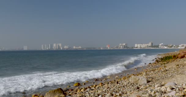 Κύματα που σκάνε στην ξηρά, με τα ξενοδοχεία και υψηλής υψώνεται στο παρασκήνιο — Αρχείο Βίντεο