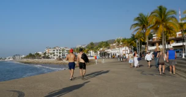 Soldyrkare och turister promenader längs malecon Puerto Vallarta, Mexico — Stockvideo