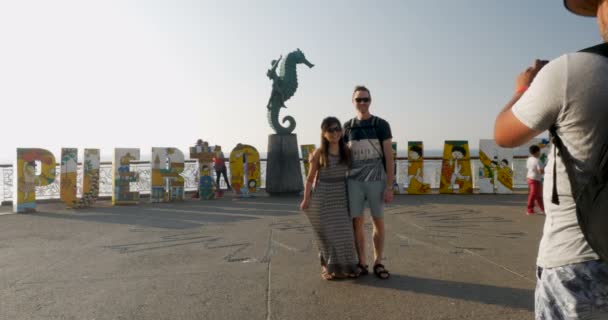 Zarejestruj człowiek fotografie dwóch turystów przed sztuki Puerto Vallarta w Meksyku — Wideo stockowe