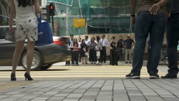 Asiáticos caminando y esperando en un cruce para cruzar una calle concurrida — Vídeos de Stock