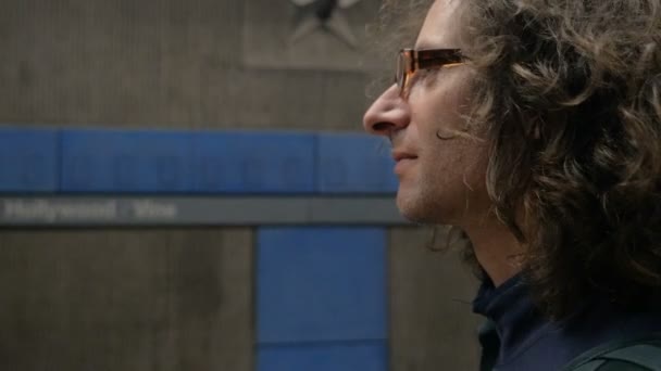 Profilo di un bell'uomo sulla trentina con occhiali e capelli lunghi al vento — Video Stock