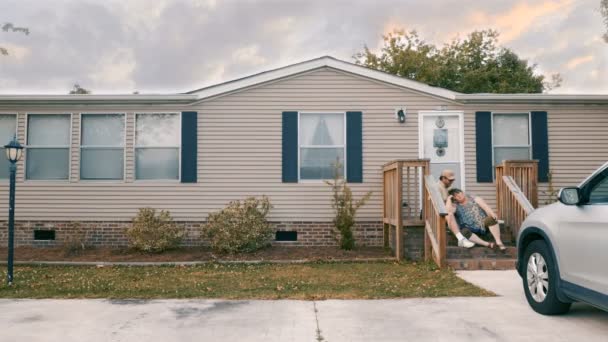 Любящие домовладельцы сидят перед своим домом и разговаривают — стоковое видео