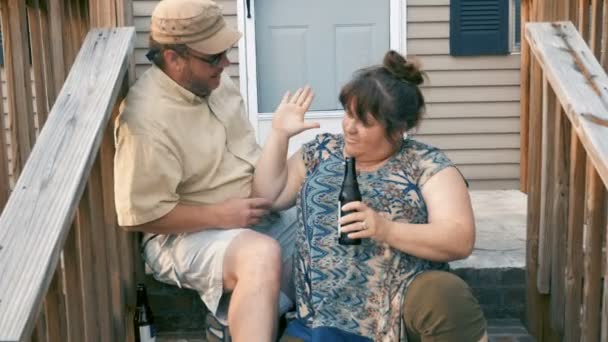 Happy successful couple high five while sitting on their front steps — Stock Video