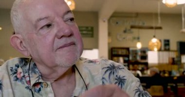 Dinleme ve Evet başını başını sallayarak bir kafede içki kırmızı şarap yaşlı adam