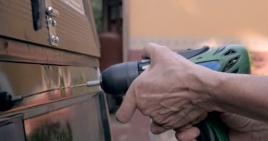 Bir kamyonun arkasına sondaj Akülü matkap tutan el yakın çekim