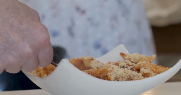 老头的手搅拌叉子与通心粉面食, 香肠, 和一个红色的番茄酱 — 图库视频影像