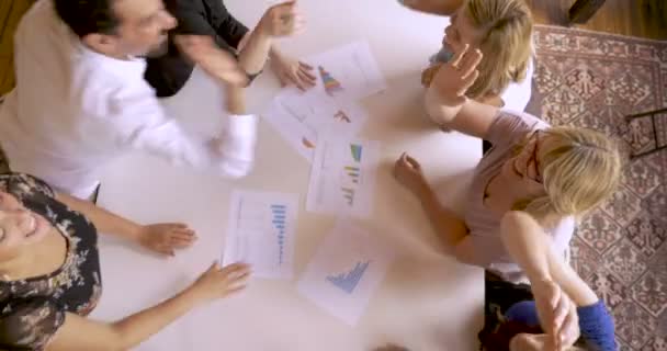 Přes hlavu pohled spuštění obchodní tým slaví s pětkou a na zdraví — Stock video