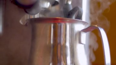 Sıcak süt ve kahve espresso makinesi arka planda damlayan pot