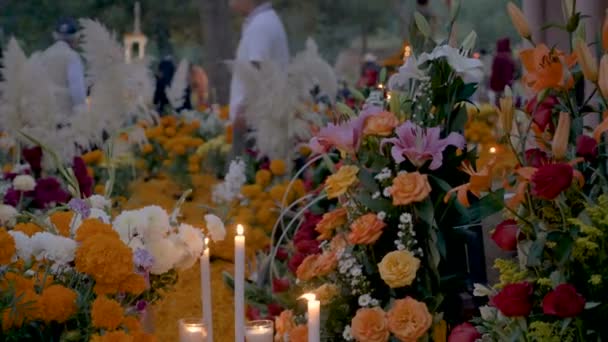 Dolly schot van bloem boeketten en kaarsen bij de graven tijdens dag van de doden — Stockvideo