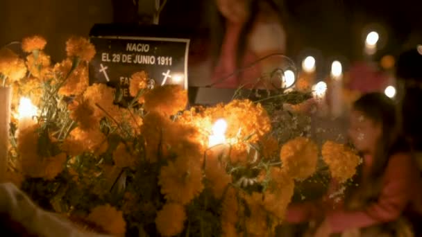 İki genç Meksikalı kız Ölülerin günü bir mezarı çiçeklerle dekorasyon — Stok video