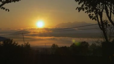 Bulutlar ve powerlines ile bir dağ Gölü üzerinde güneş ayarı
