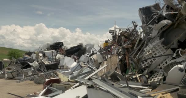 Wide shot van een stuk van vuilnis gegooid in een stapel van gerecycled metaal — Stockvideo