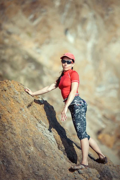 Mulher feliz sobe uma rocha enquanto trekking ao ar livre — Fotografia de Stock